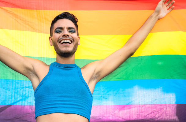 szczęśliwy homoseksualista człowiek świętuje gej duma gospodarstwa tęcza flaga symbol z LGBTQ społeczność - Zdjęcie, obraz