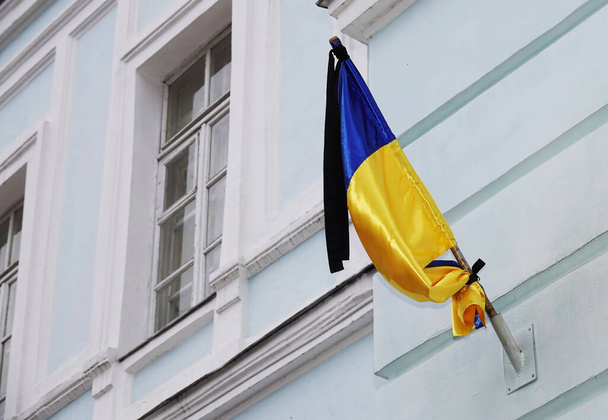 Bandera de Ucrania en un edificio con una cinta negra de luto - Foto, Imagen