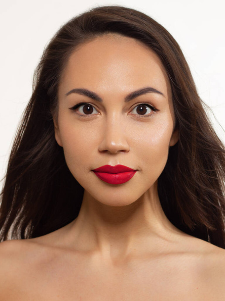 The beautiful brunette with evening cosmetics. Clean and smooth skin of the woman. Fashionable cosmetics.Bright shadows and lipstick. Cosmetology. Red chubby lips. Long eyelashes. Permanent make-up - Photo, image