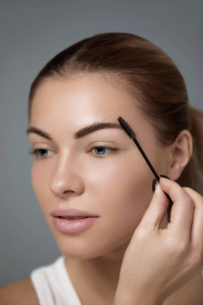 Eyebrows correction. Shape. Beautiful young woman with perfect natural eyebrows and eyelashes.  Natural make up. Beauty. Eyebrows and eyelashes close up - Foto, Imagem