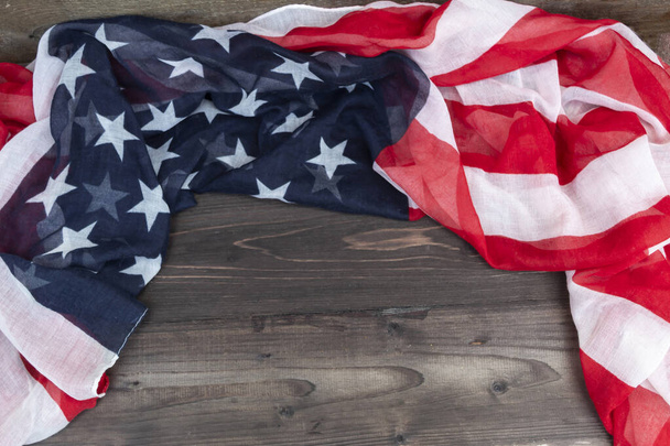 The American flag lies on a wooden background. - Φωτογραφία, εικόνα