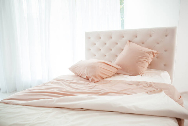 Cozy bedroom interior, Large bed by the window in pastel colors, - Foto, imagen