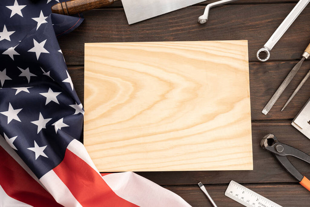 Vista superior de la bandera americana, herramientas de trabajo y tablón de madera en blanco para texto. Plantilla Mock up. Día del trabajo concepto de fondo - Foto, Imagen