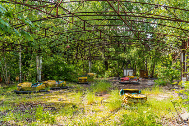 A view of abandoned bumper cars in the decaying amusement park of Pripyat, Ukraine inside the Chernobyl Exclusion Zone - Photo, Image