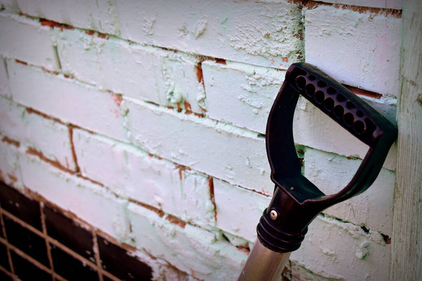 пластиковая рукоятка лопаты к стене - Фото, изображение