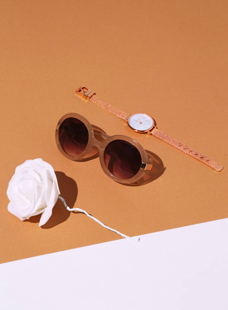 Minimal fashion still life scene. Trendy accessory retro sunglasses and watch in white beige space. Shopping, business, gift, sale concept. Stylish details in look - Foto, imagen