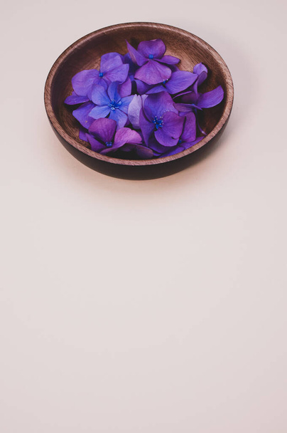 A bowl of fresh hydrangea flowers isolated on a light background with free space for text - Zdjęcie, obraz