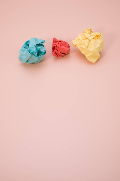 A vertical shot of aligned crumpled colored paper isolated on a pink background with copyspace - Foto, imagen