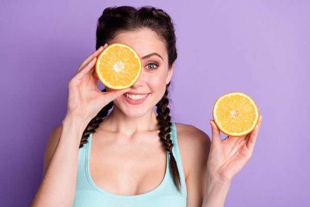Portrait of cute sweet brown hair lady show oranges wear blue top isolated on pastel purple color background - 写真・画像