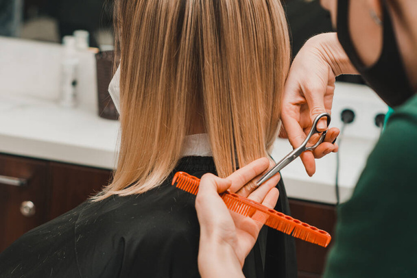 Redresse les extrémités des cheveux par un coiffeur, coupe de cheveux dans un salon de coiffure. nouveau - Photo, image