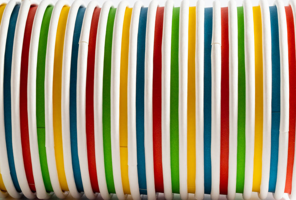 Copas de papel multicolores, tazas desechables sobre un fondo blanco. - Foto, imagen
