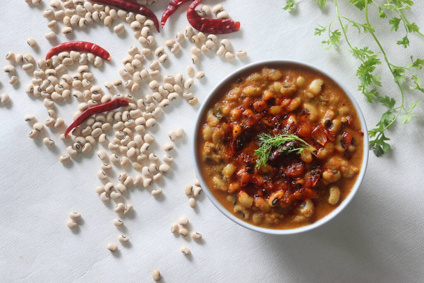 A gravy with white cowpea beans also known as black eyed pea. Boiled cowpea beans simmered in a rich gravy of onions, tomatoes, coconut and spices. Garnished with coriander leaves - Photo, Image