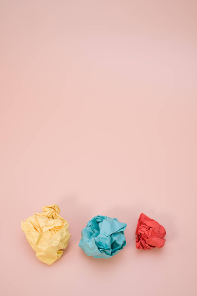 A vertical shot of aligned crumpled colored paper isolated on a pink background with copyspace - Фото, зображення