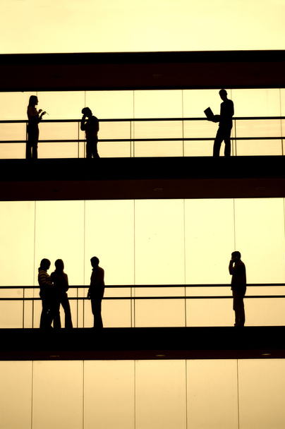 Silueta de los trabajadores en tono sepia en un edificio moderno
 - Foto, Imagen