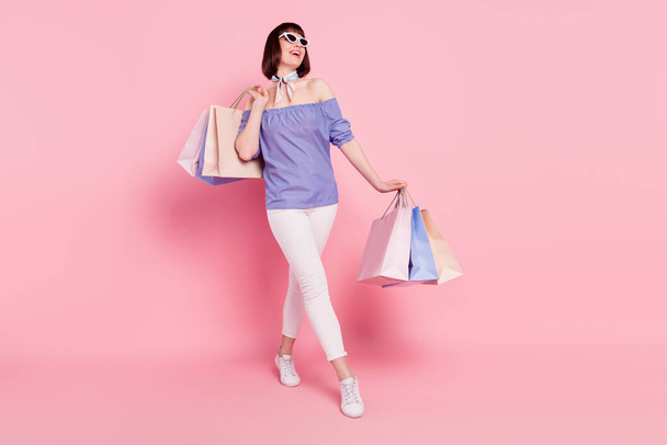 Full length body size photo woman with packages walking in shopping mall overjoyed dreamy isolated pastel pink color background - Fotografie, Obrázek
