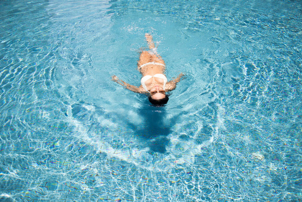 Asijská žena relaxovat na vodní bazén v létě šťastný opalování na bazén a bikiny suite a sluneční brýle   - Fotografie, Obrázek