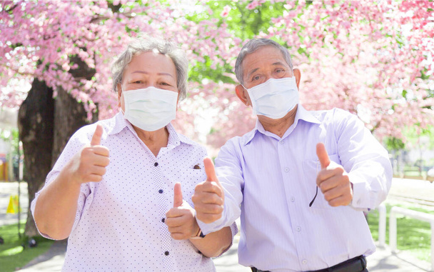 Az ázsiai idősek magabiztossága kiment arcpakolással a Coronavirus világjárványban. Öreg férfi és nő orvosi maszkot visel, hogy megvédje Covid-19-et az új normális viselkedésben. - Fotó, kép
