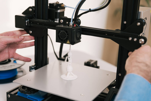 Ingeniero joven en el laboratorio ajustando componentes de impresoras 3D - Foto, imagen