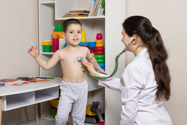 Pediatr vyšetřuje plíce a srdce otroka pomocí fonendoskopu. Ausculation, diagnóza pneumonie u dětí - Fotografie, Obrázek
