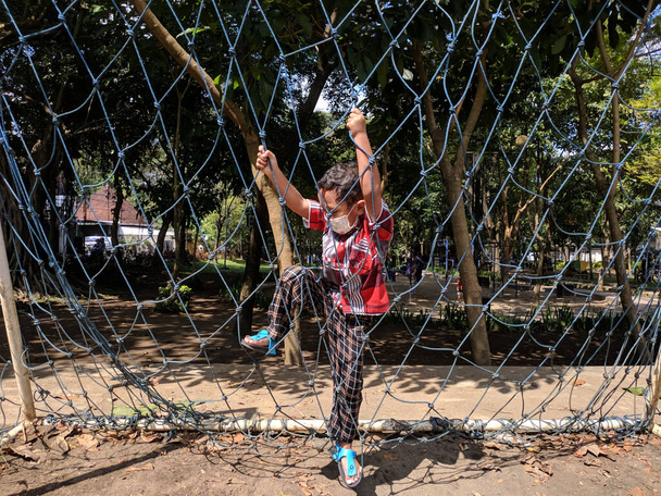 ein Junge, der in einem kleinen Tor in einem Park in der Stadt Malang Futsal spielte - Foto, Bild
