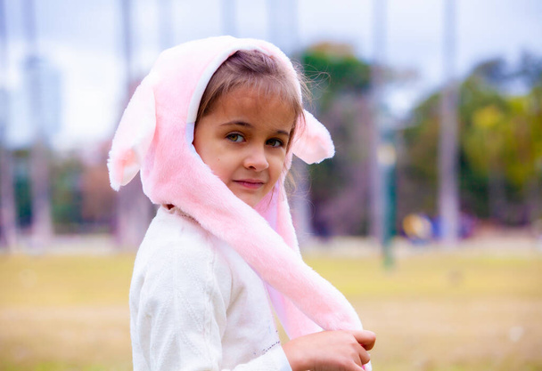 happy girl in pink hare hat in the park - Fotoğraf, Görsel