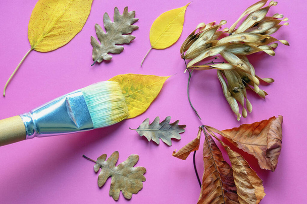  Осень и школьные представления. Осенние листья и кисть на розовой бумаге - Фото, изображение