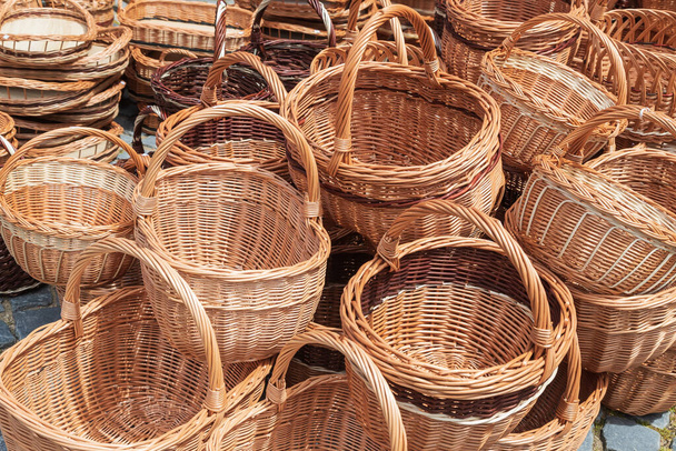Different sizes of wicker baskets stacked on the ground. - Zdjęcie, obraz