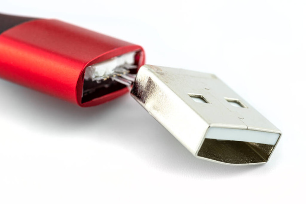 Makro ujęcie czerwonego uszkodzonego końca kabla USB 2.0 A, izolowanego na białym tle. - Zdjęcie, obraz