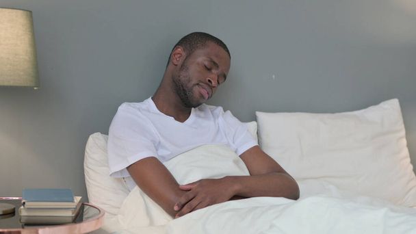Sleepy joven africano tomando siesta en la cama  - Foto, Imagen