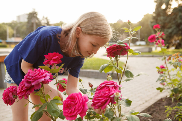 Młoda dziewczyna pachnąca kwiatami w mieście - Zdjęcie, obraz