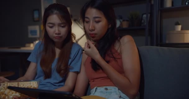 Attraktive asiatische Damen mit lässigen genießen glückliche Augenblicke Fokus Online-Filmunterhaltung auf Tablet essen Popcorn-Website auf der Couch Wohnzimmer zu Hause in der Nacht. Konzept der Lebensstilaktivität Quarantäne. - Filmmaterial, Video