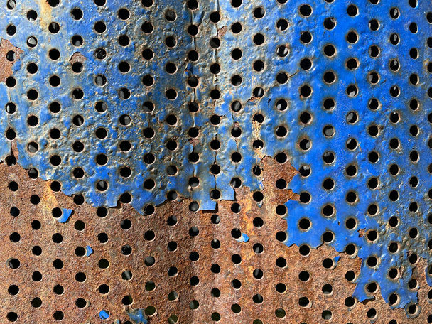 Старий метал з отворами. Блакитна фарба відшаровується, є іржа. На відкритому повітрі
 - Фото, зображення