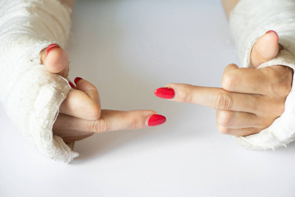 deux mains féminines aux poignets cassés après être tombées d'une bicyclette dans un plâtre sur un fond isolé, les mains dans un plâtre - Photo, image