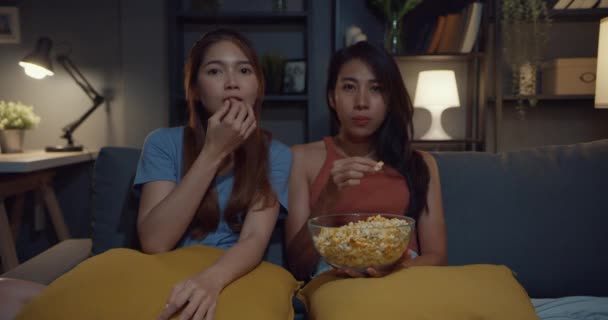 Keyifli bir anı olan çekici Asya 'lı çift geceleri evdeki kanepe oturma odasında patlamış mısır yiyen online film eğlencesi izliyor. Yaşam tarzı aktivite karantina konsepti. - Video, Çekim