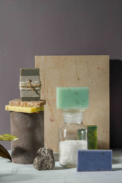 Handgemachte Seife mit natürlichen Extrakten, aromatischem Badesalz und natürlichem Bimsstein. Stilvolle Komposition auf einem Marmorhintergrund - Foto, Bild