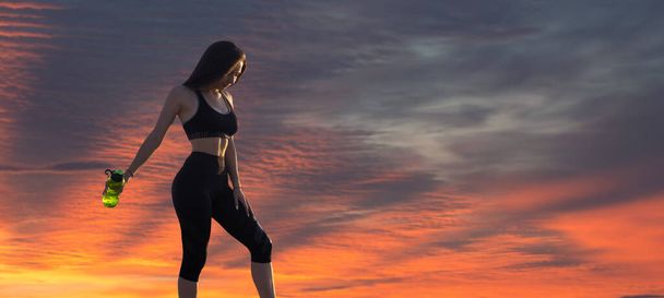 Uma menina magro desportivo em leggings e um topo está de pé com um tapete de treinamento, descansando entre os exercícios. Fitness e estilo de vida saudável. - Foto, Imagem
