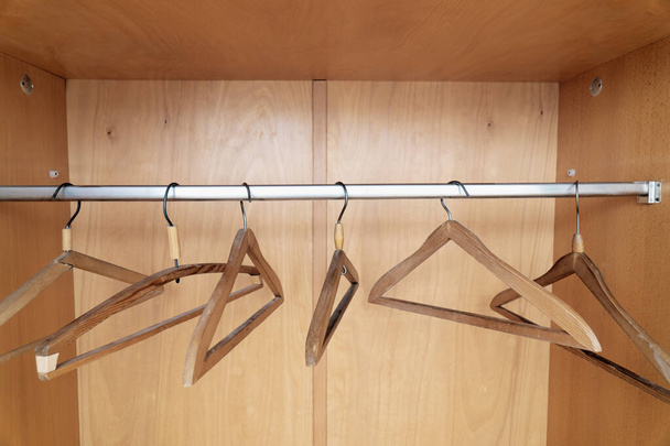 Dřevěné věšáky na kabáty pověšené ve staré skříni - Fotografie, Obrázek