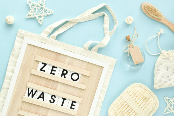 A sign with the inscription Zero waste on a fabric bag on a light blue background. Flat layout, top view, a place to copy. - Zdjęcie, obraz