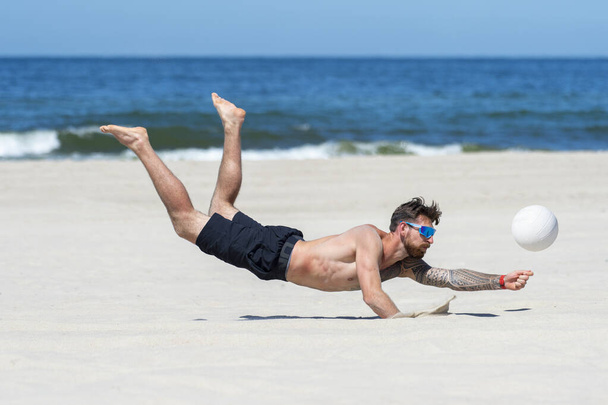 Professionele beachvolleybalspeler in actie, ontvangt de bal. Horizontale sportposter, wenskaarten, headers, website - Foto, afbeelding