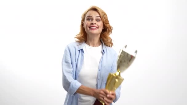 εξαιρετικά χαρούμενο κορίτσι με χρυσό κύπελλο πρωταθλητή φιλώντας το βραβείο, τρόπαιο - Πλάνα, βίντεο