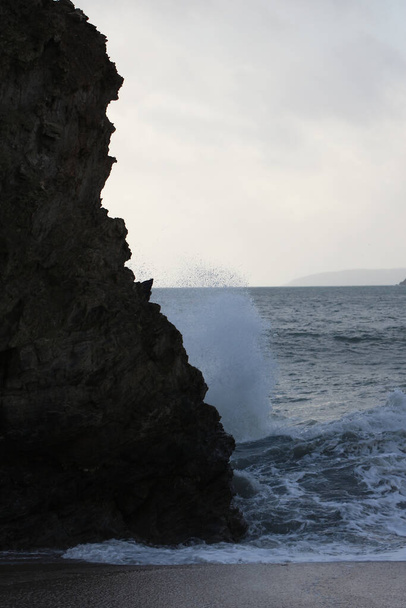Olas de tormenta atlánticas rompiendo y lavándose sobre rocas y arena en la playa de la bahía de Carlyon en Cornwall en la costa suroeste de Inglaterra - Foto, Imagen