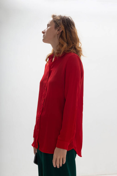 caucasian redheaded woman with long hair in red shirt on white background - Zdjęcie, obraz