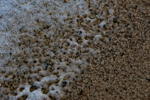 Атлантические штормовые волны обрушиваются и омывают скалы и песок на пляже залива Карлион в Корнуолле на юго-западном побережье Англии - Фото, изображение