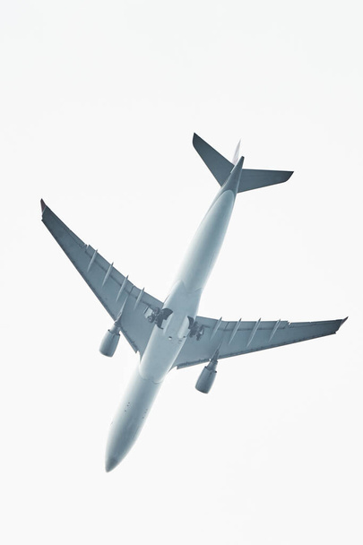 Egy repülő sziluettje az égbolton. Kereskedelmi repülőgép jetliner repül a felhők felett gyönyörű nappali fényben. A légi közlekedés légiközlekedési háttérkoncepciója. Repülőgép az égen - Fotó, kép