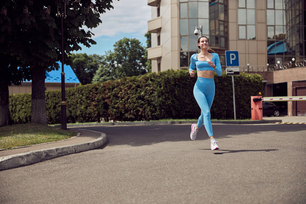 Belle forme jeune femme jogger est en cours d'exécution à l'extérieur - Photo, image
