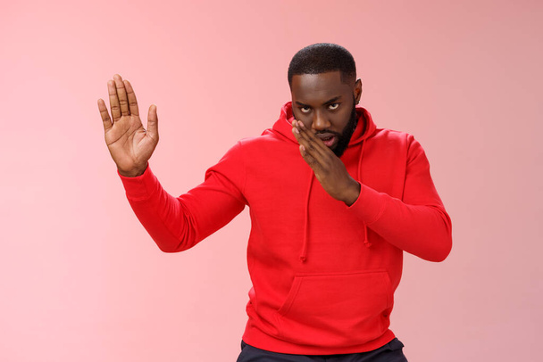 Guy knows asian fighting skills. Portrait serious-looking funny african-american young man perform martial arts standing kung-fu karate pose raised palms, pink background, better not mess with me - Photo, Image