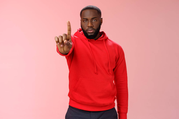 Wait second. Serious-looking annoyed strong brutal african american older brother show index finger number one explaining important rule look bossy solid, standing pink background forbid something - Photo, Image