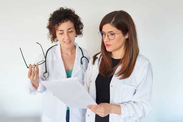 Dvě doktorky se dívají na dokumenty a diskutují o diagnóze - Fotografie, Obrázek