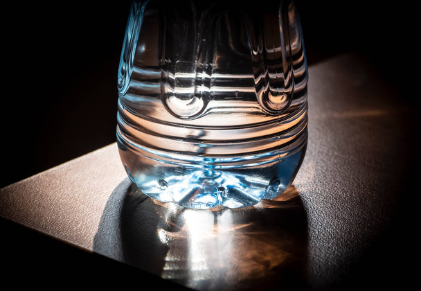 Plastic bottle with water is on the table near the wall close-up. - 写真・画像