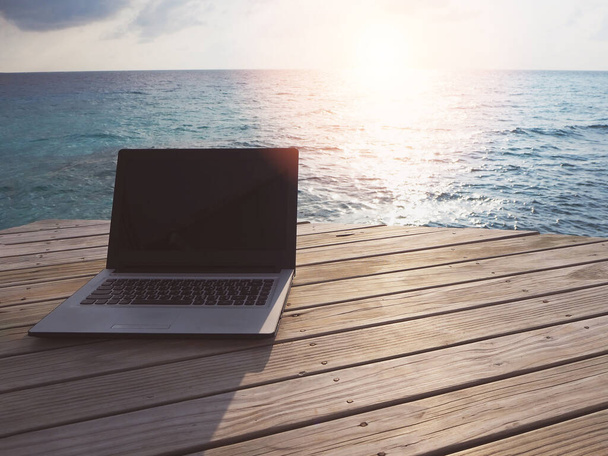 Комп'ютерний ноутбук на дерев'яній терасі перед прекрасним бірюзовим морем на Мальдівському тропічному острові, відпустка відпочиває від природи влітку. - Фото, зображення
